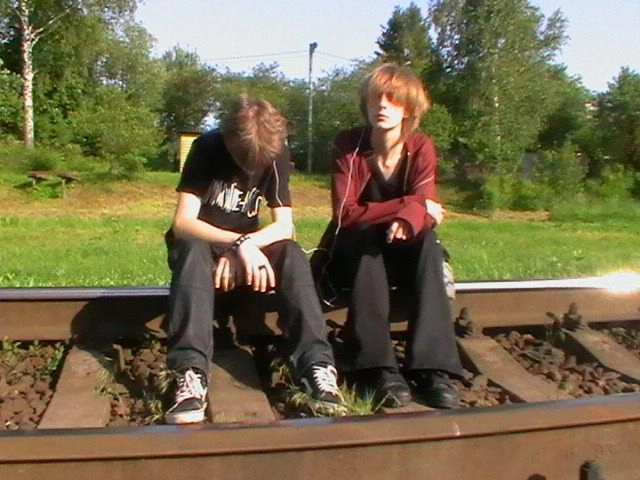 A group of people sitting on top of a train track.