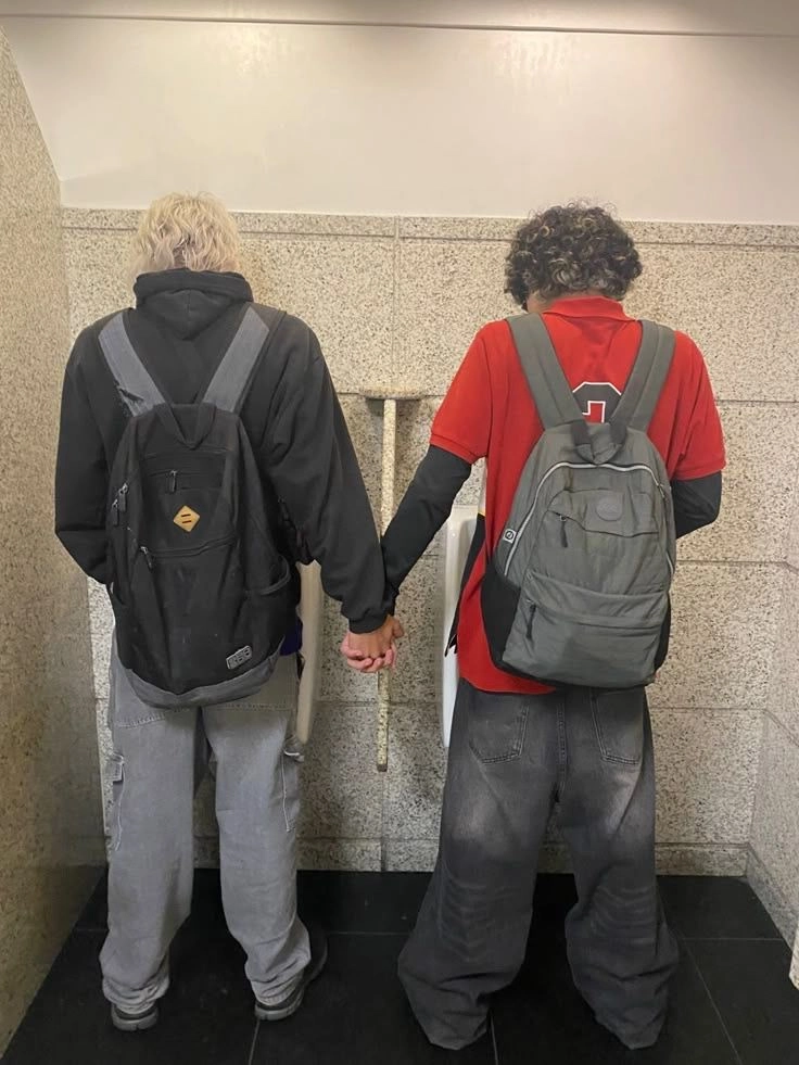 A couple of people standing next to each other holding hands.