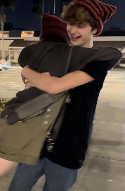 A man and a woman hugging each other on a street.