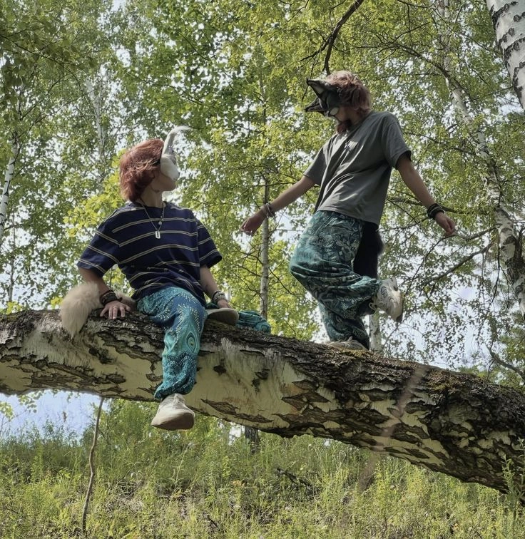 A couple of people sitting on top of a tree branch.