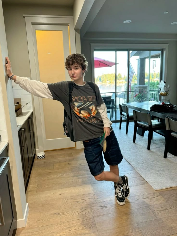 A man standing in a kitchen with his arms outstretched.