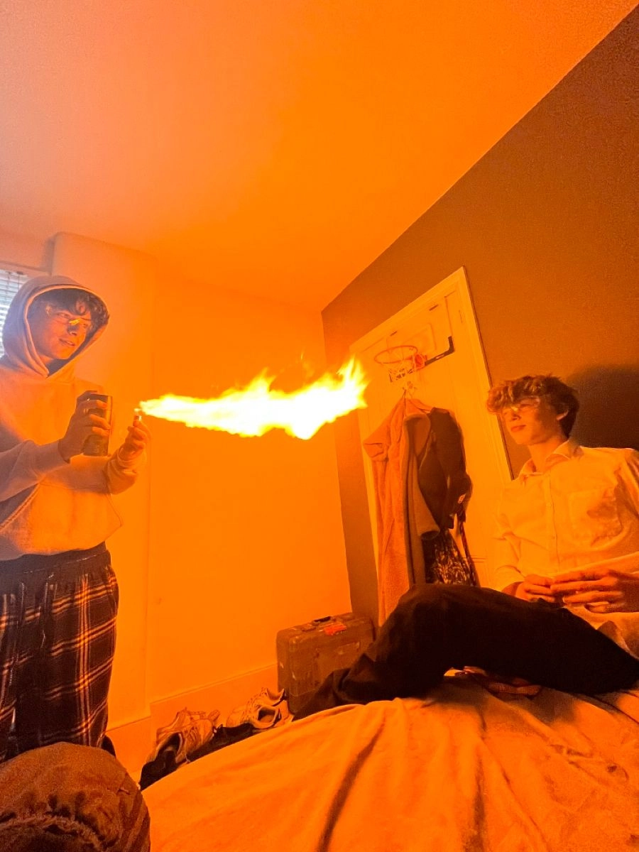 A group of people standing around a bed with a fire in their hand.