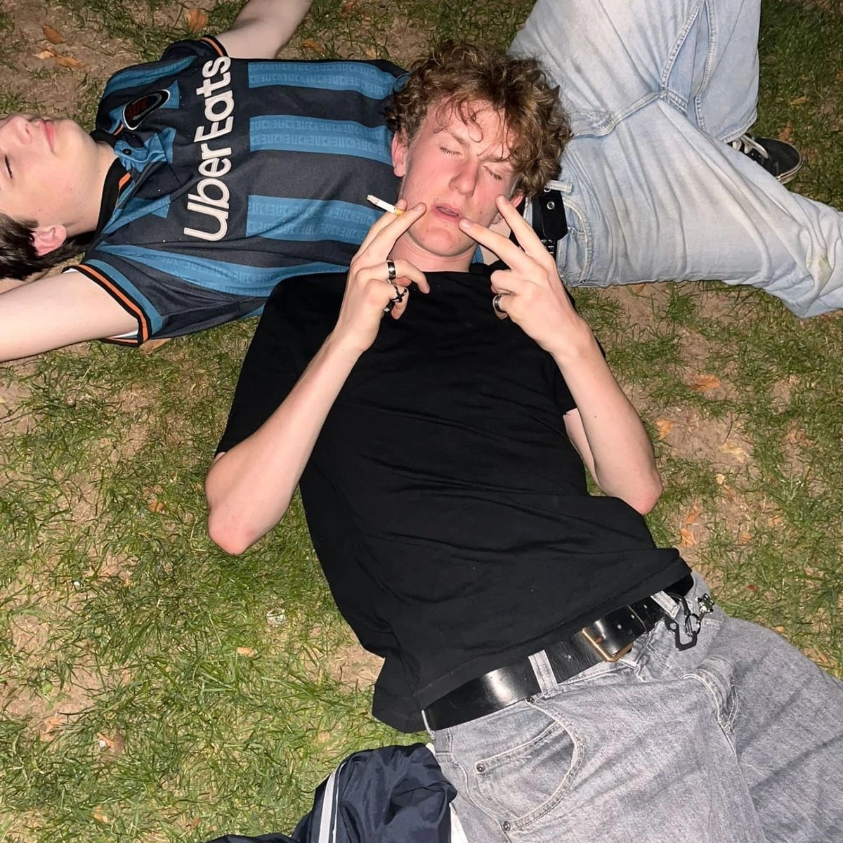 A group of people laying on top of a grass covered field.