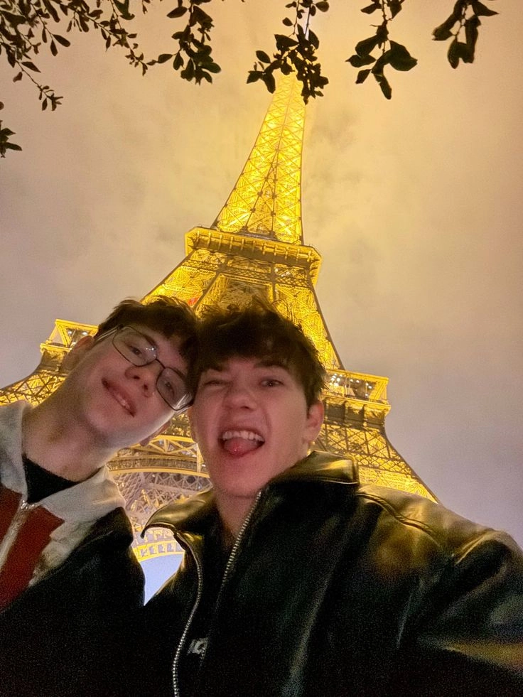 A group of young men standing in front of the Eiffel Tower.