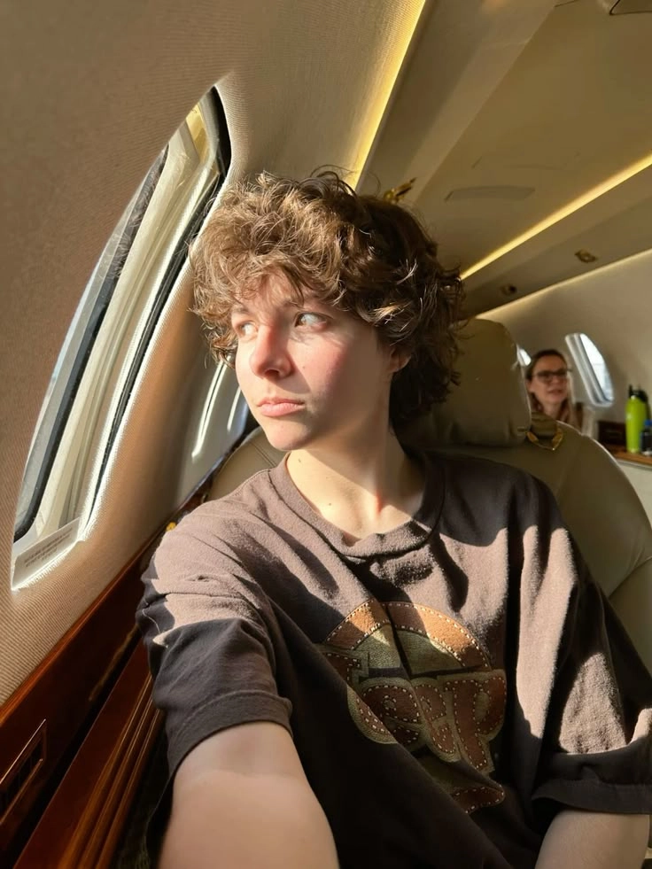 A young man sitting in the back of a private jet.