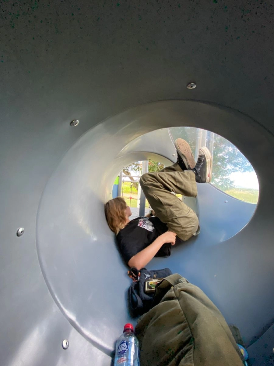 A couple of people laying on top of a metal structure.