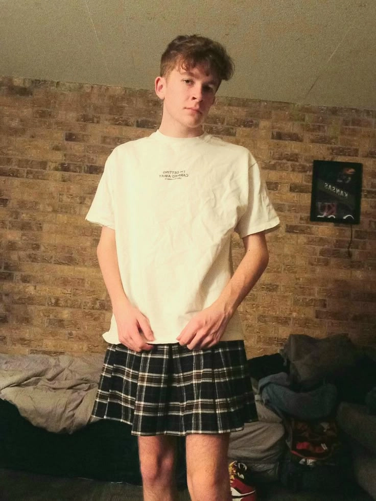 A young man standing in front of a pile of clothes.
