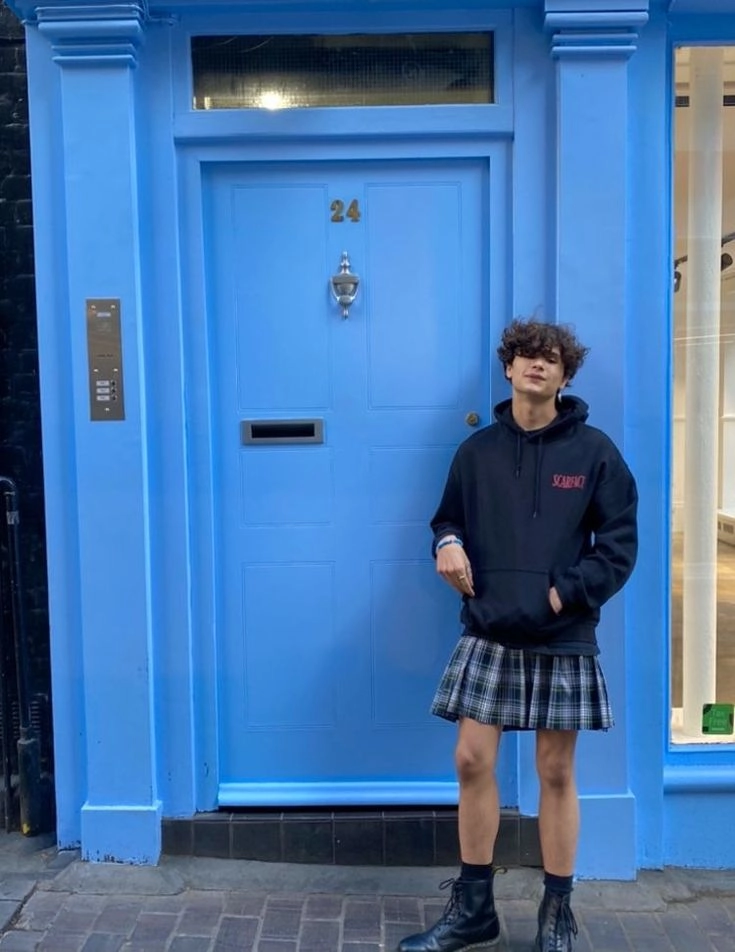 A man standing in front of a blue door.