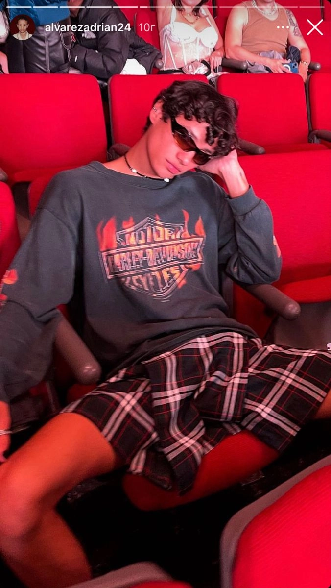 A man sitting in a movie theater with his head in his hands.