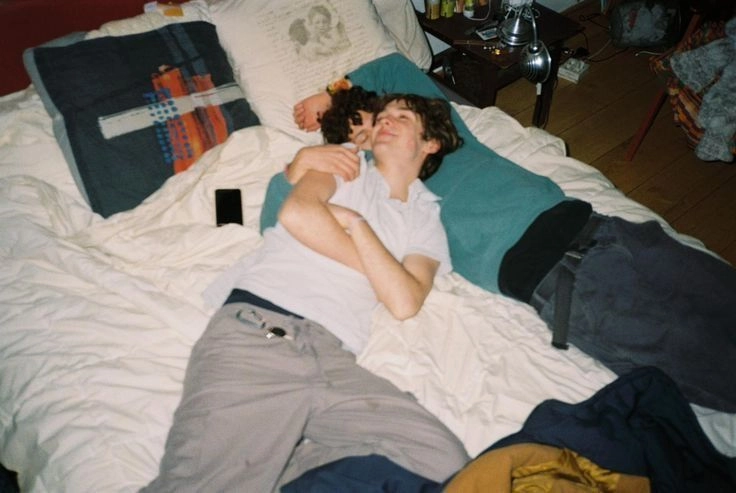 A couple of people laying on top of a bed.