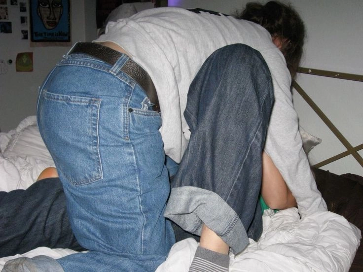 A couple of people that are sitting on a bed.