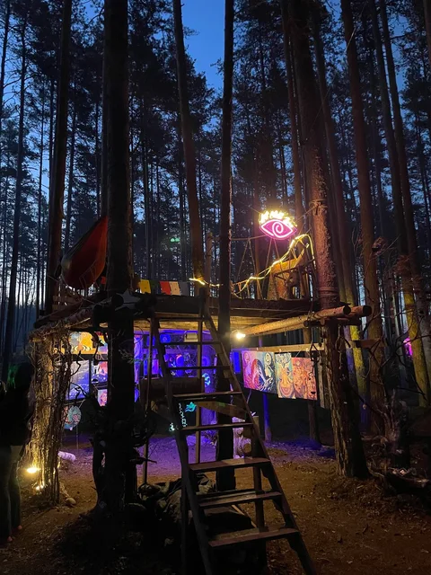 A wooden structure in the middle of a forest at night.