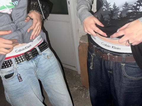 A pair of jeans with a belt on the waist.