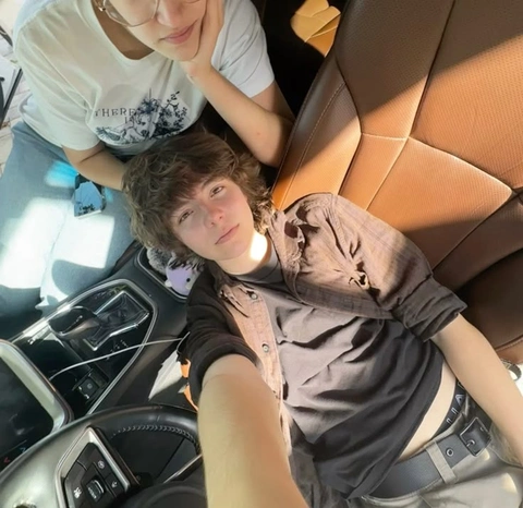 A group of people sitting in the back seat of a car.