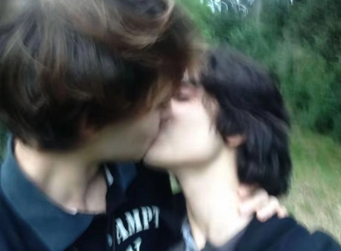 A group of young women kissing each other in a park.