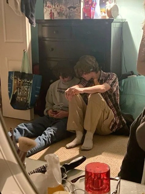 A group of people sitting on the floor in a room.