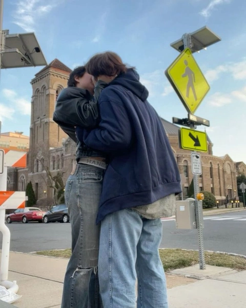 A couple of people standing next to each other on a street.