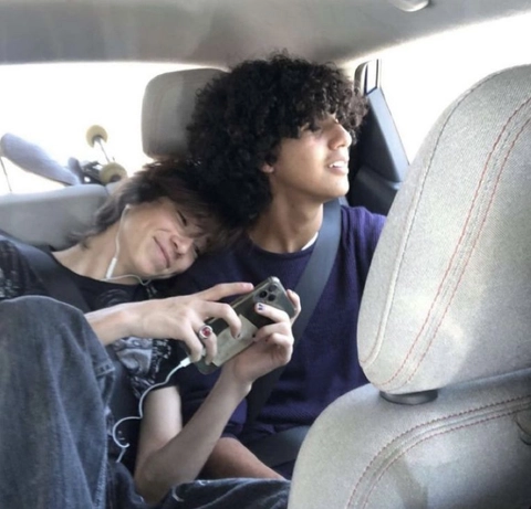 A couple of people sitting in the back seat of a car.