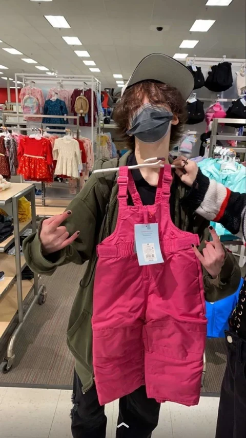 A mannequin wearing a pink overalls and a hat.