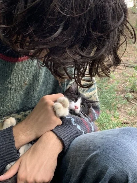 A man holding a cat in his hands.