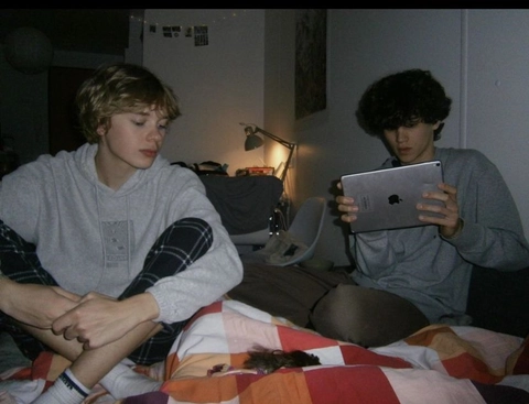 A couple of people sitting on top of a bed.