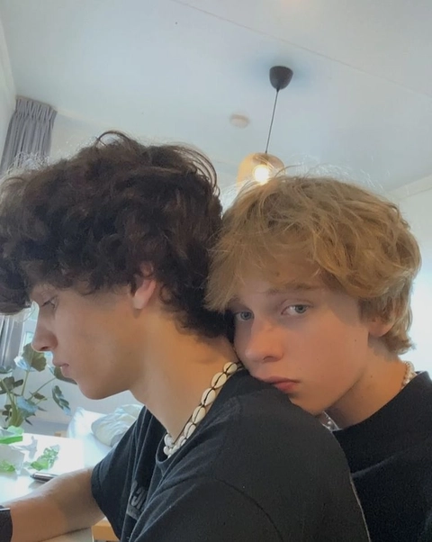 A group of young men with curly hair sitting at a table.