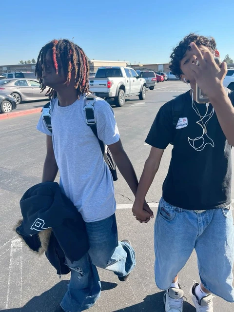 A couple of people that are standing in a parking lot.