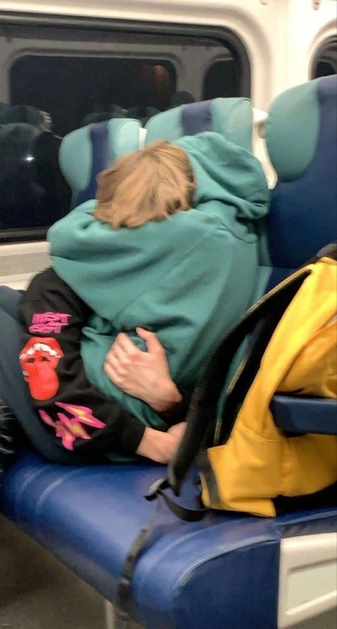 A couple of people sitting on top of a train.
