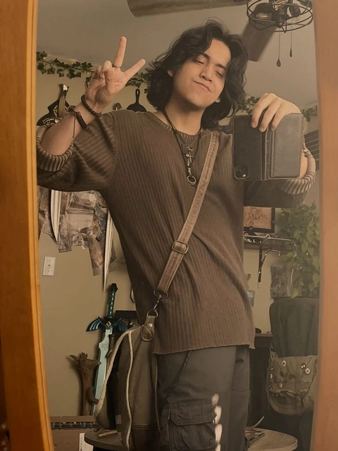 A man standing in front of a mirror holding up a cell phone.