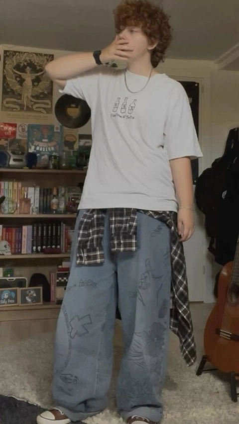 A young man in a white shirt and plaid pants.