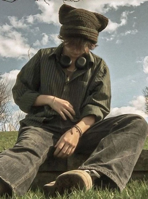 A man sitting on top of a wooden bench.