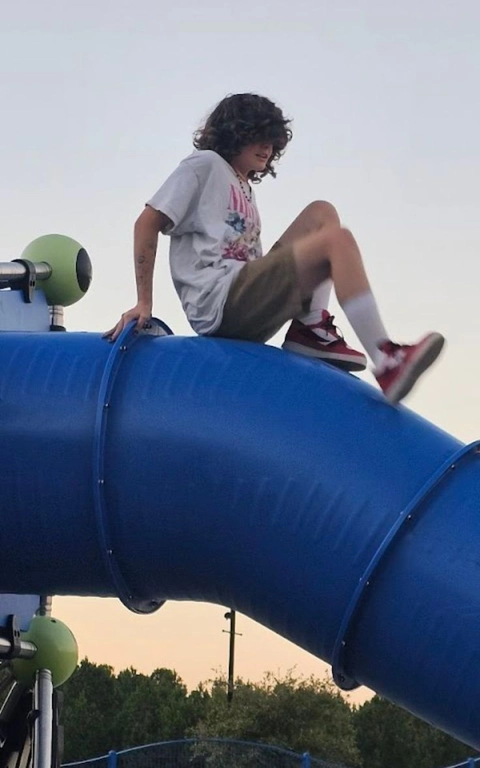 A man and a woman are sitting on a slide.