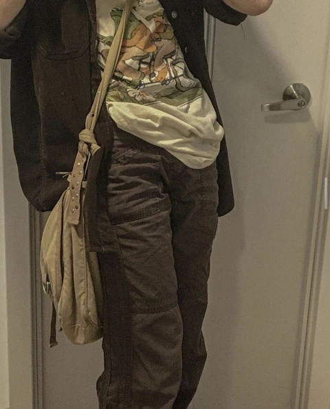 A person holding a purse in front of a mirror.