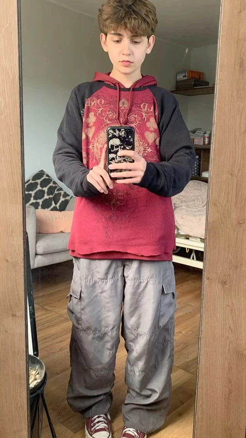 A young boy taking a picture of himself in a mirror.
