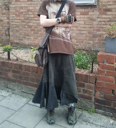 A man in a costume standing in front of a brick wall.