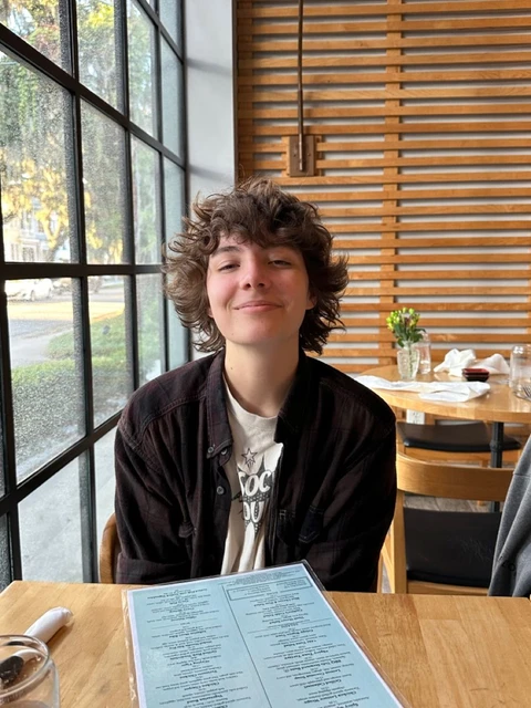 A young man sitting at a table with a menu.