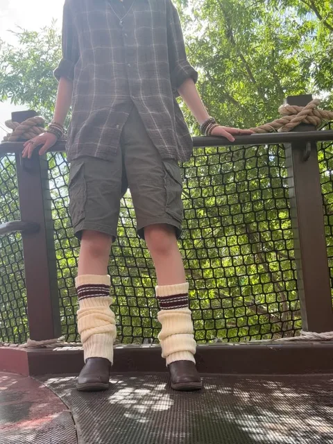 A mannequin wearing a pair of socks standing on a bridge.