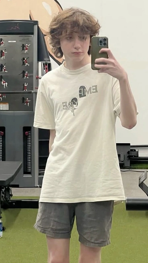 A young man taking a picture of himself in a mirror.