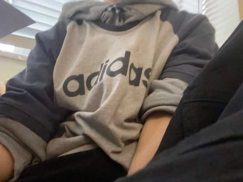 A woman wearing a hoodie sitting on a bench.