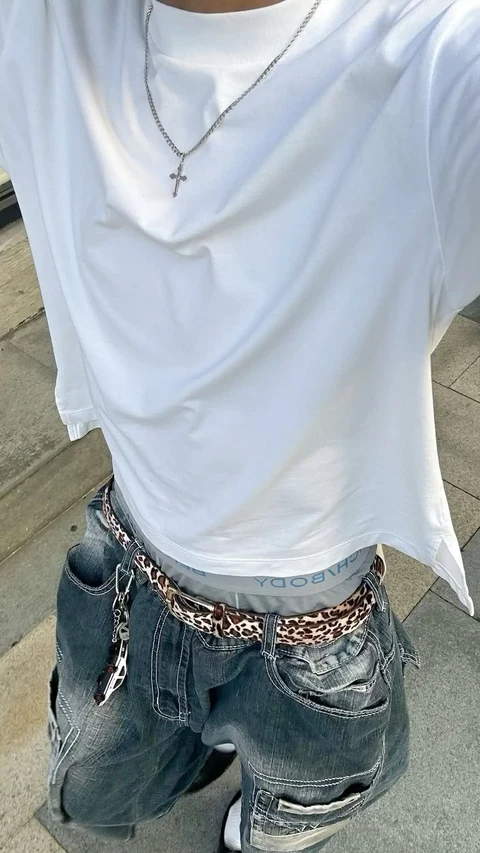 A woman wearing a white shirt and a leopard print belt.