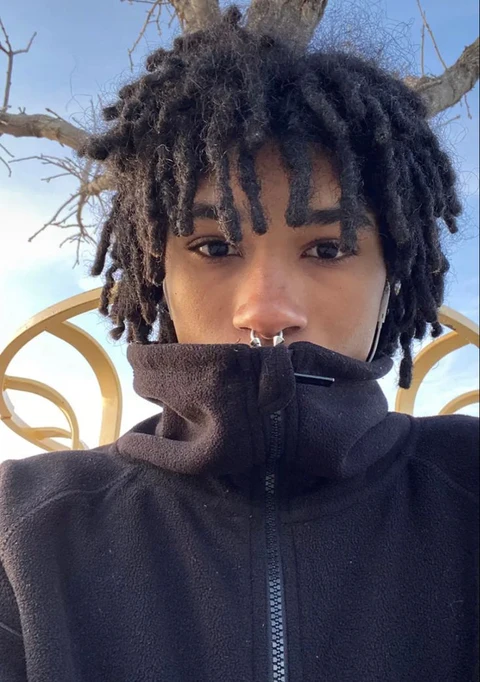 A woman with dreadlocks sticking out her tongue.