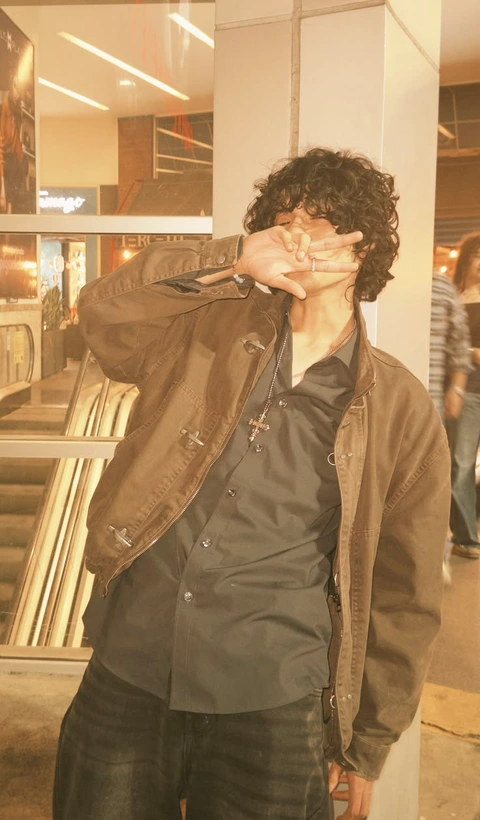 A mannequin dressed as a man with curly hair.