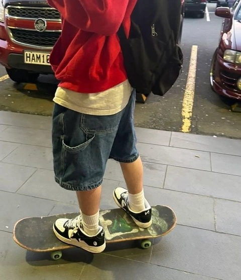 A person standing on a skateboard in the middle of a street.