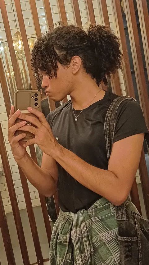 A young man taking a picture of himself in a mirror.