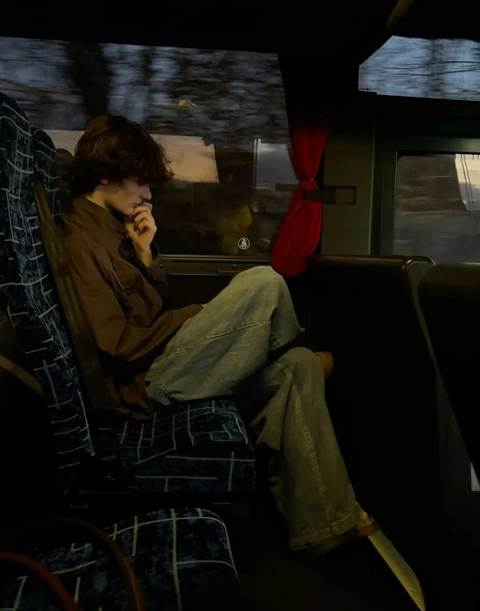 A man sitting on a bus talking on a cell phone.