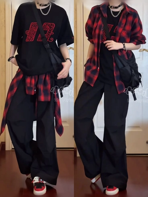 A woman wearing a black and red plaid shirt and black pants.
