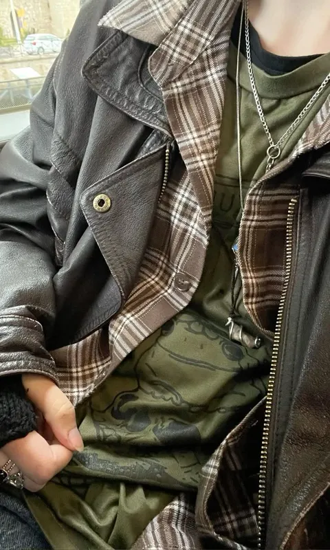 A mannequin wearing a black and green plaid jacket.