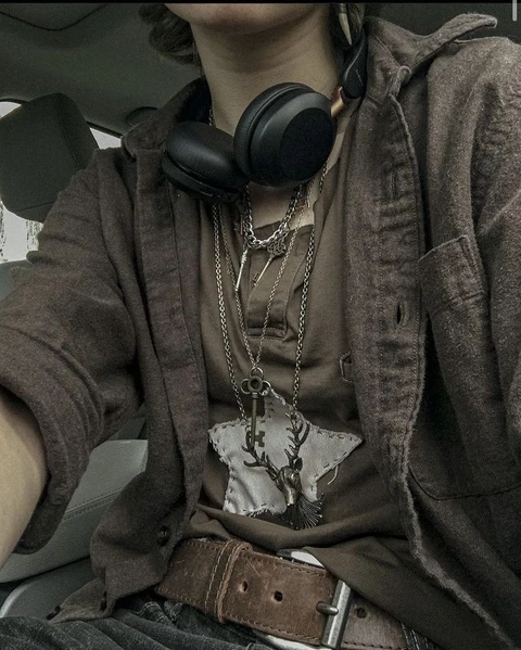 A man wearing headphones sitting in the back seat of a car.