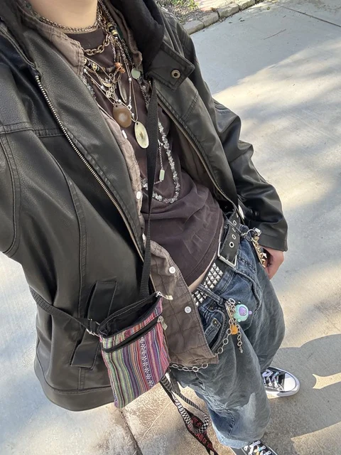 A woman with dreadlocks standing on a sidewalk.