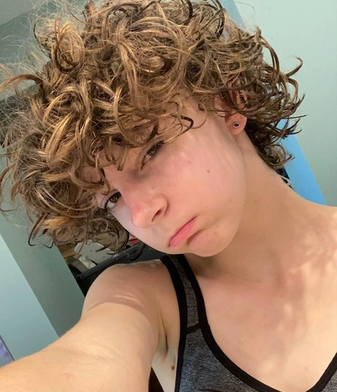 A woman with curly hair taking a selfie.